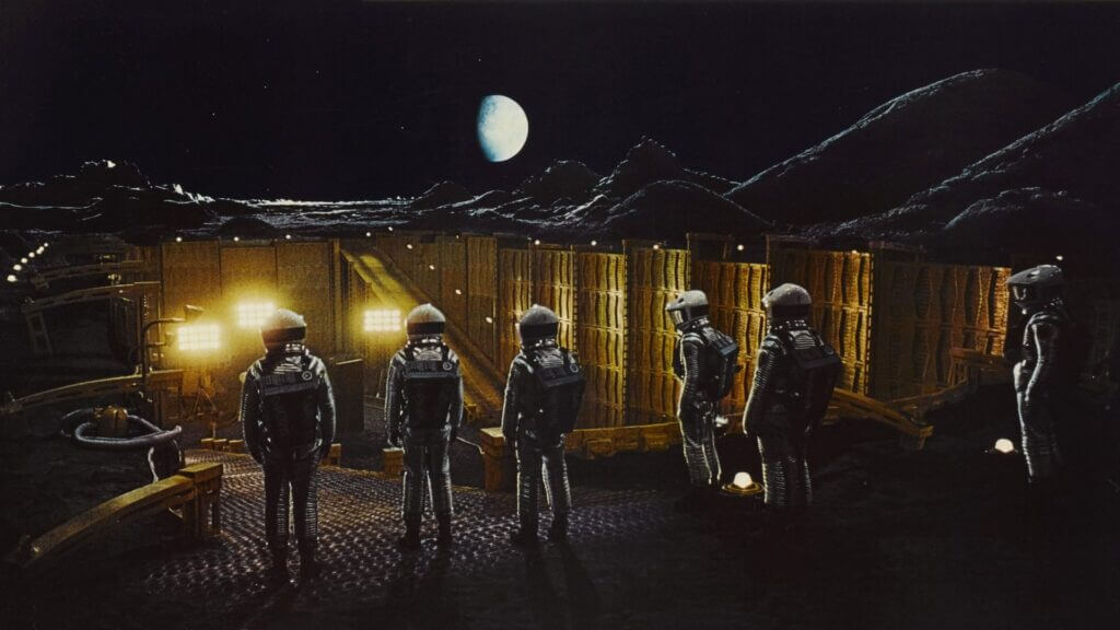 Des astronautes inspectent un monolithe sur la lune dans une scène du film 2001, l'odyssée de l'espace de Stanley Kubrick