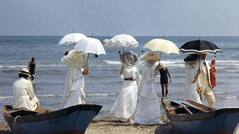 De riches vacanciers sur la plage dans une scène du film Mort à Venise