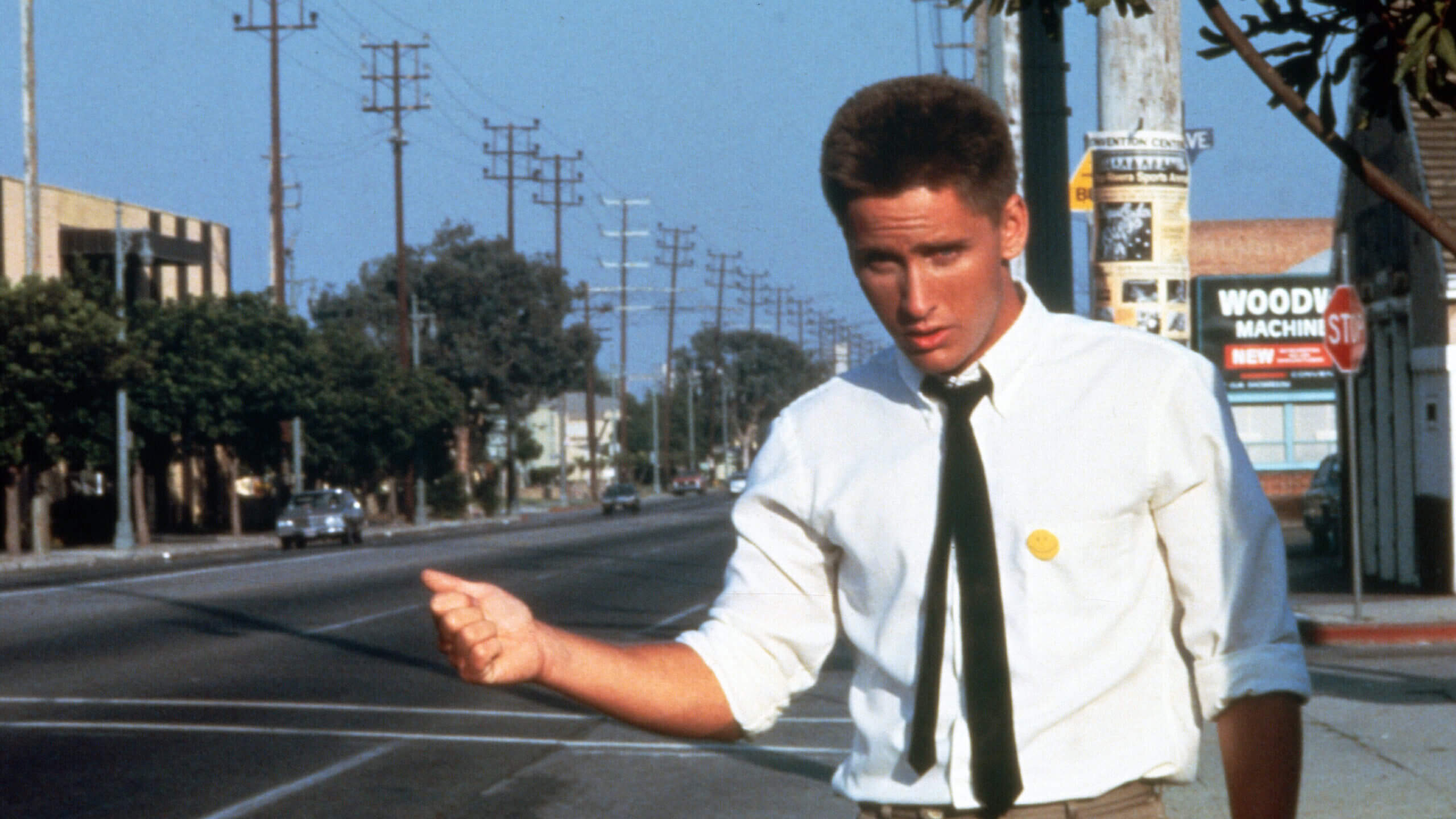 Otto (Emilio Estevez) fait de l'auto-stop sur l'autoroute dans une scène du film Repo Man.