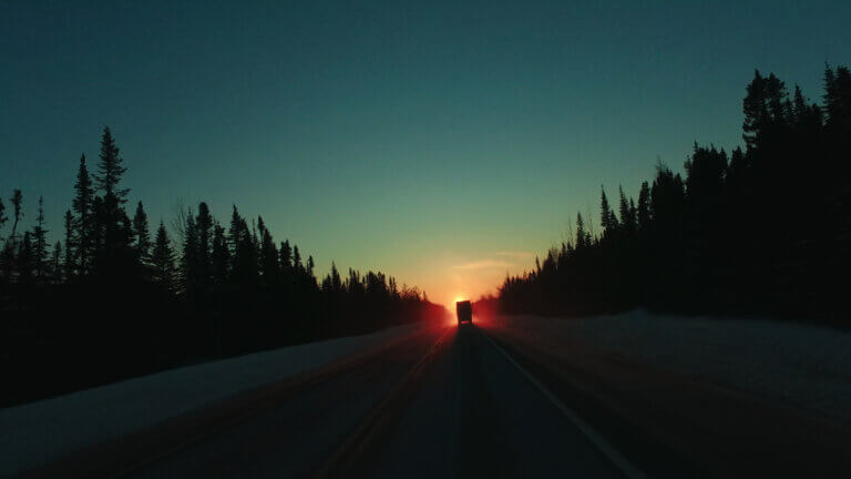 Le soleil se lève au bout d'une route dans une scène du film La cartomancie du territoire.