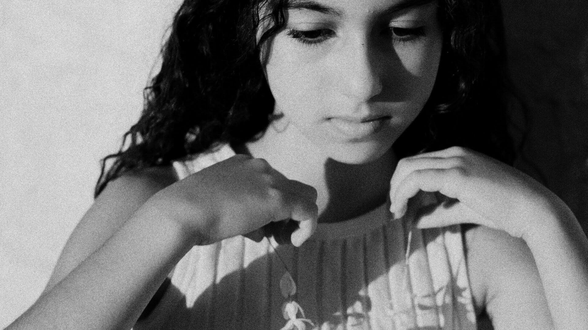 Une image en noir et blanc d'une jeune fille dans une scène du film The Poem We Sang d'Annie Sakkab.