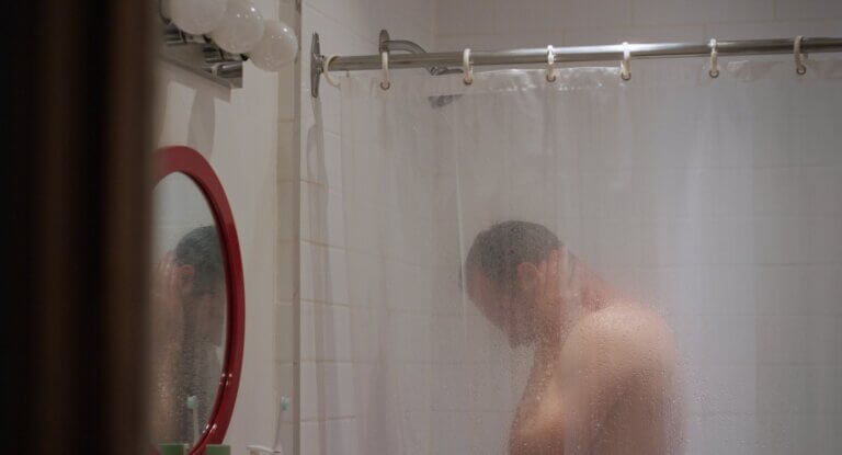 Un homme sous la douche dans une scène du film Chronique d'une crise.