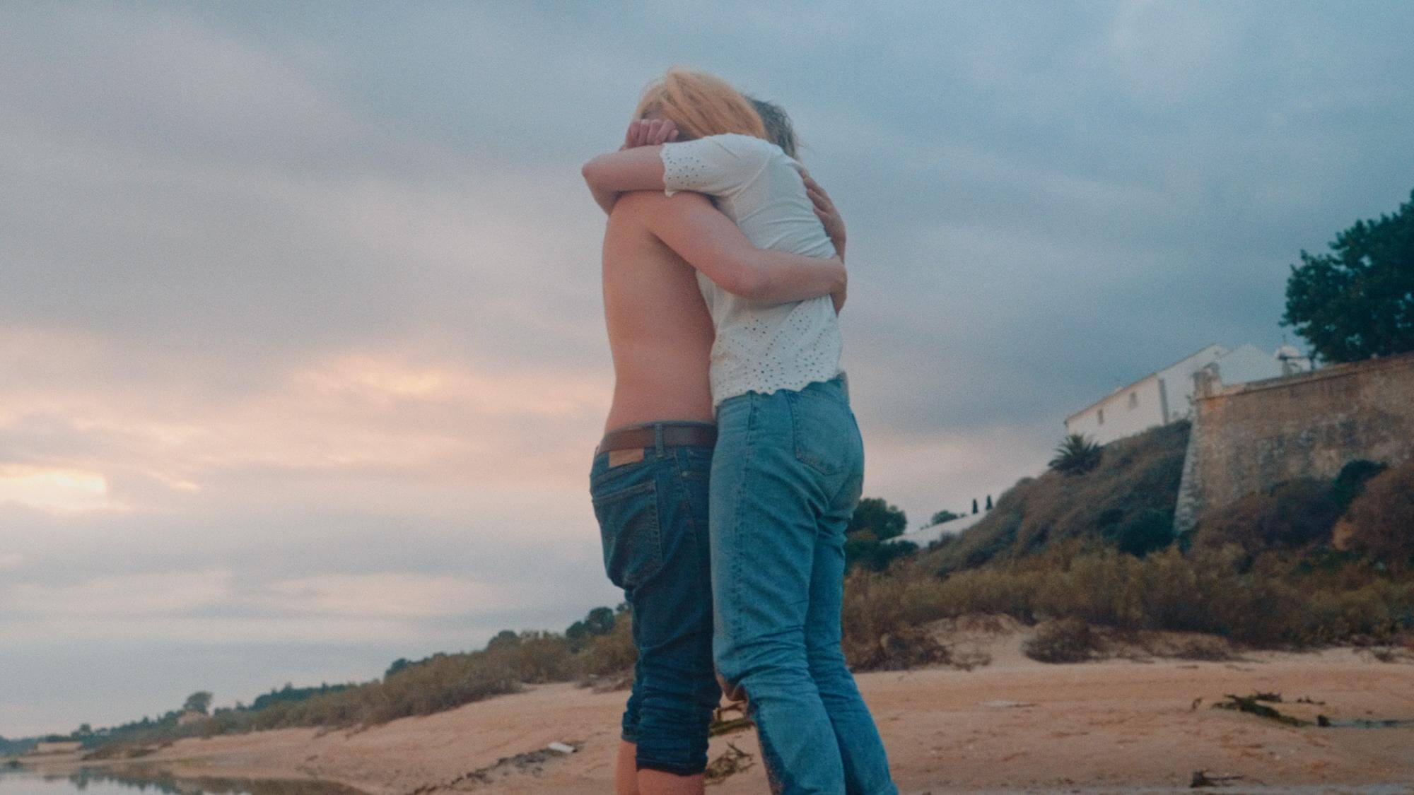 Deux personnes s'étreignent sur une plage dans une scène du film Tout sur Margo.