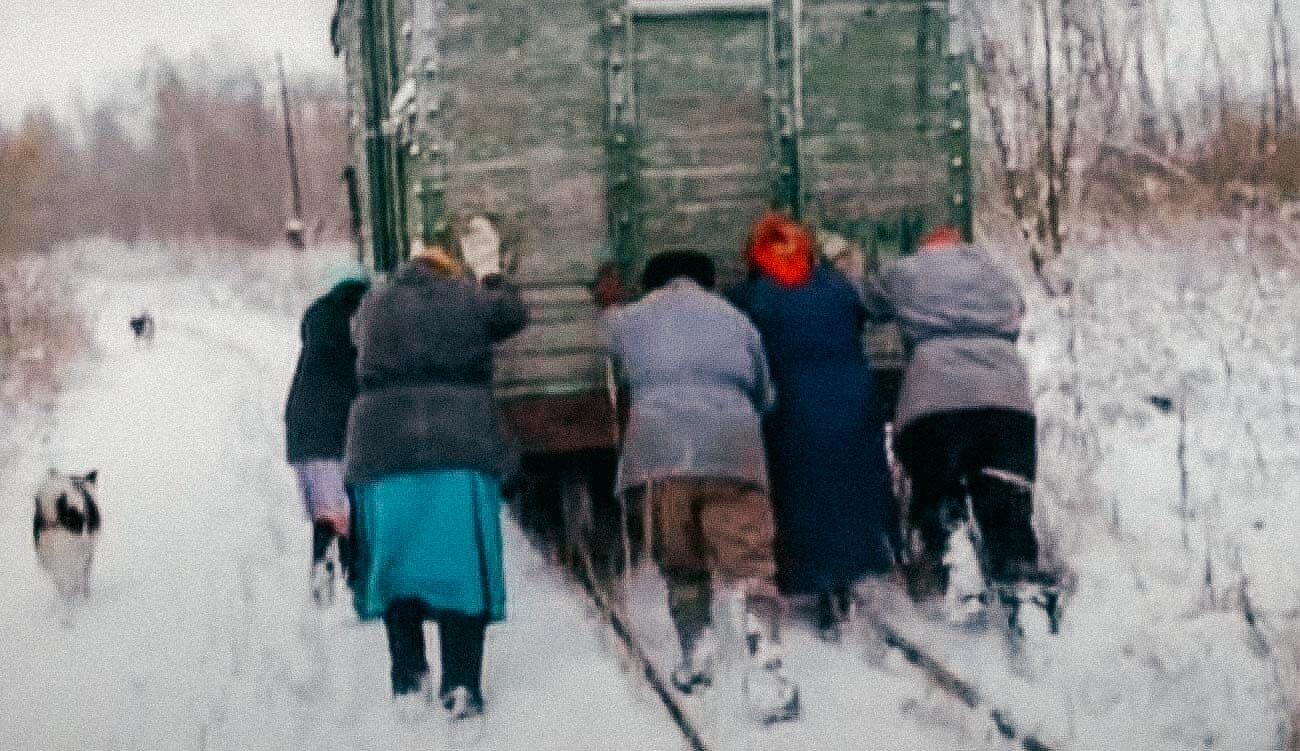 Des villageois russes poussent un wagon de train dans la neige dans une séquence du documentaire Bread Day.
