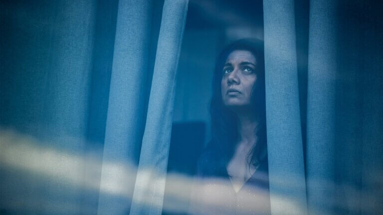 Une femme regarde par la fenêtre.