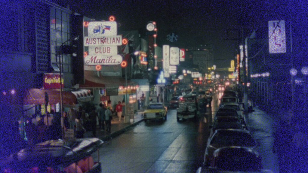 Une rue de Manila illuminée par les néons, la nuit, dans les années 1980.