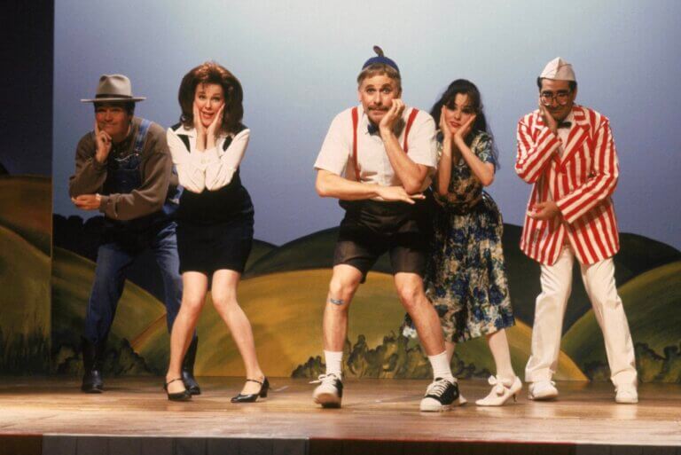 Une troupe de théâtre amateur en pleine performance sur une petite scène communautaire.