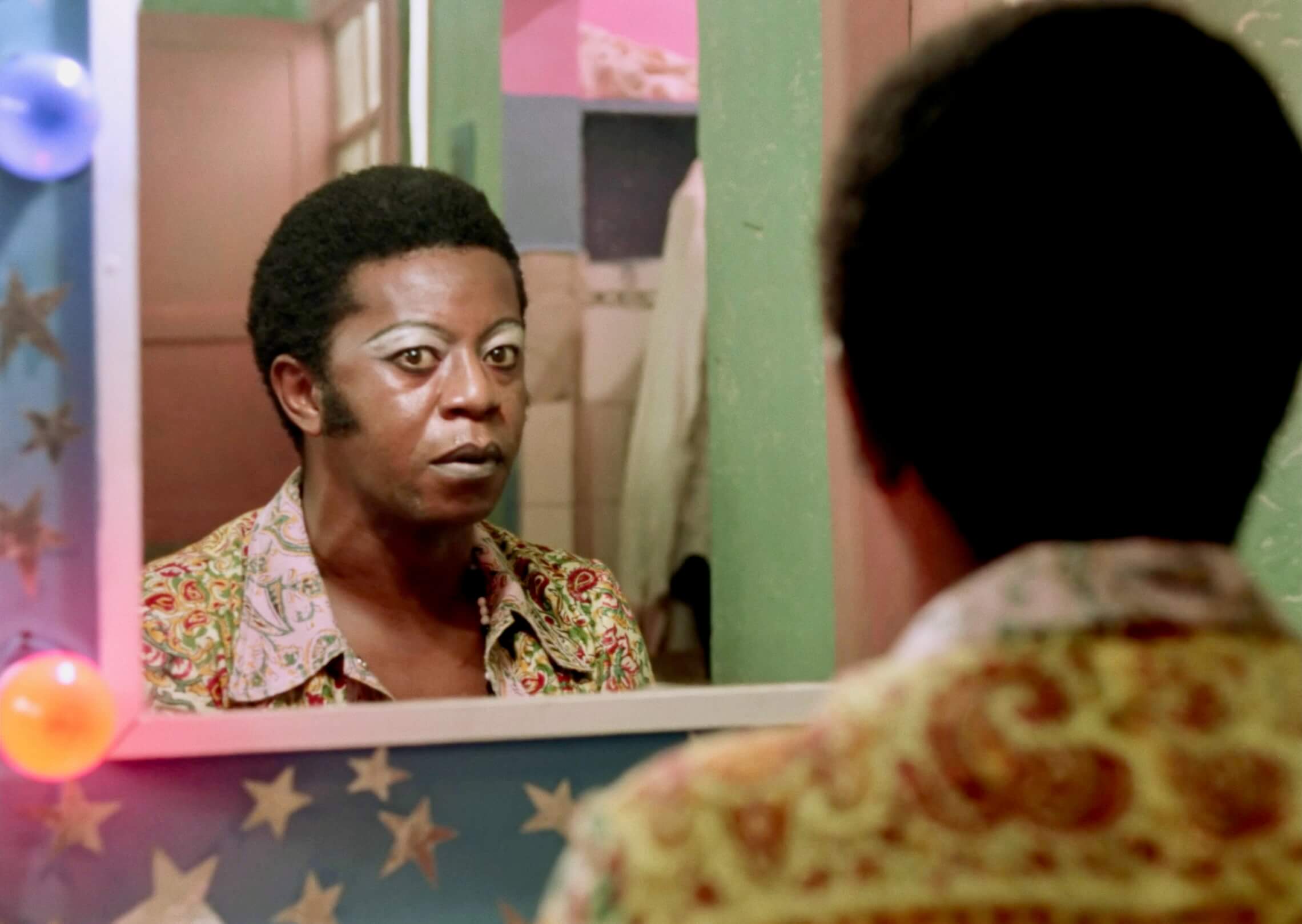 Diaba, reine du crime, regarde son reflet dans le miroir.